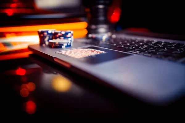 A woman smiling while playing online games on her laptop, surrounded by neon casino elements, showcasing CD33’s diverse game collection.